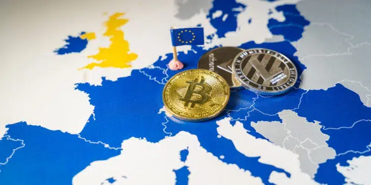 Monedas físicas con logos de criptomonedas arriba de un mapa europeo.